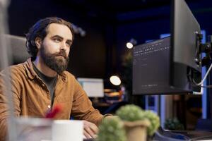 Software developer typing lines of code using keyboard, filtering malicious traffic from cybercriminals attempting to steal company data. IT professional preventing malware and phishing attacks photo