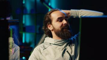 Charismatic streamer in neon illuminated studio chatting with audience, inviting them to pick game for him to play. Energetic gamer interacting with viewers watching his livestream photo