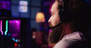 Zoom in on man enjoying coop FPS videogame, battling flying robots with his online friends. Close up of gamer chatting with internet teammates while playing first person shooter game, fighting boss photo