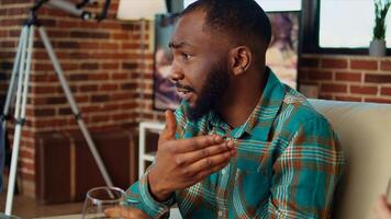 Close up on african american man telling entertaining story to women at apartment party during weekend gathering. Group of friends listening to funny tale from host in living room, zoom in shot photo