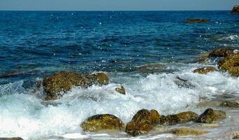 White waves on stones near the shore near the steep limestone shores and rocks in the tract Dzhangul, western Crimea photo