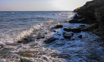 Waves roll on the stone coast of pontic limestone in the Crimea photo