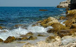 White waves on stones near the shore near the steep limestone shores and rocks in the tract Dzhangul, western Crimea photo