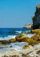 White waves on stones near the shore near the steep limestone shores and rocks in the tract Dzhangul, western Crimea photo