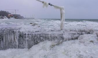 Frozen Black Sea, ice-covered and frozen coastal rocks in the piers, harsh winter photo