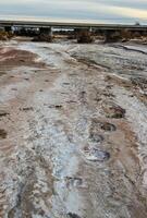 Cracked red clay and white salt on the surface in a dried riverbed in the desert of New Mexico, USA photo