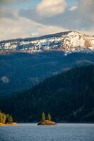 Mountains in the snow, overgrown with wood. Thick clouds over the mountains. photo