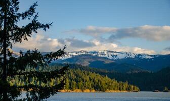 Mountains in the snow, overgrown with wood. Thick clouds over the mountains. photo