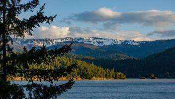Mountains in the snow, overgrown with wood. Thick clouds over the mountains. photo