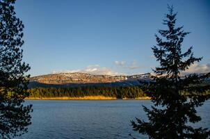 Mountains in the snow, overgrown with wood. Thick clouds over the mountains. photo