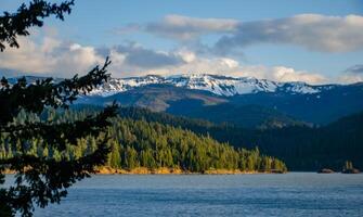 Mountains in the snow, overgrown with wood. Thick clouds over the mountains. photo