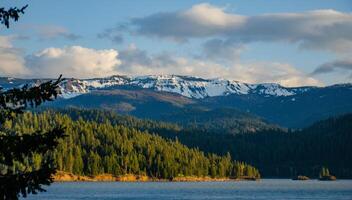 Mountains in the snow, overgrown with wood. Thick clouds over the mountains. photo