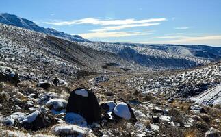 Snow in the mountains, Snow-covered mountain pass, desert plants under the snow in summer photo