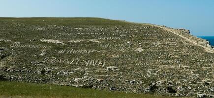 Stone inscriptions on the gentle slopes of the steppe coast of Dzhangul in the western Crimea, Tarkhankut photo