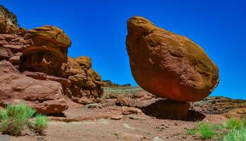 Balancing rock at the bottom of a canyon among Layered geological formations of red rocks. photo
