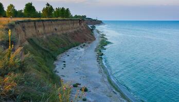 Sandy deserted beach along the steep shore of the Black Sea photo