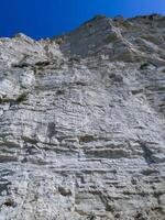 Vertical high rock made of white shell rock near the Black Sea coast near Sozopol, Bulgaria photo