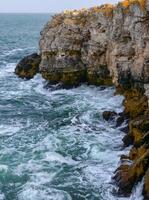 Seascape on the Black Sea, high steep stone coast with inaccessible rocks near the village of Tyulenovo, Bulgaria photo