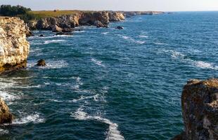 Seascape on the Black Sea, high steep stone coast with inaccessible rocks photo