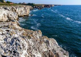 Seascape on the Black Sea, high steep stone coast with inaccessible rocks photo