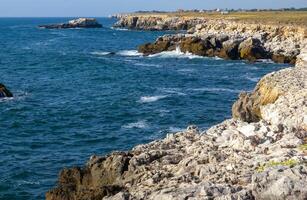 Seascape on the Black Sea, high steep stone coast with inaccessible rocks photo