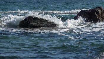 White foam and big waves crash on yellow rocks in the Black Sea during a storm photo