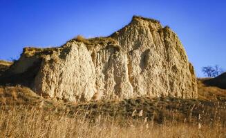 Clay cliffs of the shore of Lake Yalpug against the background of a blue sky photo
