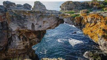 Large arch in coastal rocks made of shell rock near the village of Tyulenovo photo