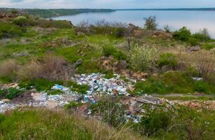 Heaps of plastic trash on the shore of the reservoir. Ecology of nature photo