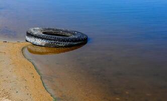 Car tires on the shore Hadzhibey estuary, Ukraine photo