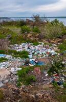 Heaps of plastic trash on the shore of the reservoir. Ecology of nature photo