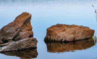 Coast with rocks in the water, Hadzhibey estuary. Reflection in water photo
