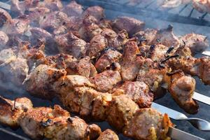Pork meat is fried on smoking coals in the grill photo
