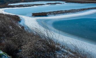 Frozen water, patterns of snow in small lakes. Tiligul estuary, Ukraine photo