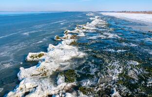 Ice floating near the shore and ice floes on the shore in the Tiligul estuary in winter, Ukraine photo