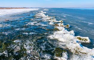 Ice floating near the shore and ice floes on the shore in the Tiligul estuary in winter, Ukraine photo