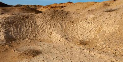 Dry cracked red clay in the desert in the bed of a dried up water stream, Egypt photo