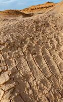 Dry cracked red clay in the desert in the bed of a dried up water stream, Egypt photo