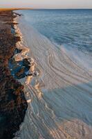 Wavy Dirty foam driven by the wind to the shore of the Tuzlovsky estuary photo