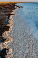 Wavy Dirty foam driven by the wind to the shore of the Tuzlovsky estuary photo