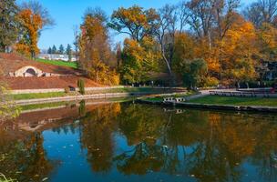 Lake in autumn with reflection in the water of trees against the backdrop of autumn vegetation photo