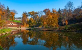Lake in autumn with reflection in the water of trees against the backdrop of autumn vegetation photo