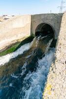 Waste water is poured into the estuary, dirty foam. Ecological problems of the reservoir. Hadzhibey estuary, Ukraine photo