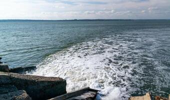 Waste water is poured into the estuary, dirty foam. Ecological problems of the reservoir. Hadzhibey estuary, Ukraine photo