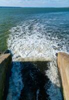 Waste water is poured into the estuary, dirty foam. Ecological problems of the reservoir. Hadzhibey estuary, Ukraine photo