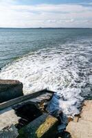 Waste water is poured into the estuary, dirty foam. Ecological problems of the reservoir. Hadzhibey estuary, Ukraine photo