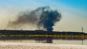 Fire smoke against the backdrop of the Kuyalnitsky estuary in the evening before sunset photo