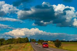 White cumulus thunderclouds in the sky over a highway, Ukraine photo