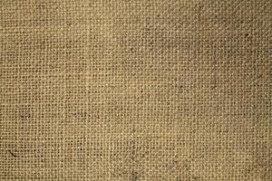 Natural Linen Material Textile Canvas Fabric Texture Background Close-up Detail of Fabric Natural Color Hemp Material Pattern Design Wallpaper. Can be Used as Background or For Graphic Design photo