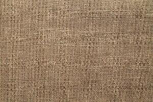 Natural Linen Material Textile Canvas Fabric Texture Background Close-up Detail of Fabric Natural Color Hemp Material Pattern Design Wallpaper. Can be Used as Background or For Graphic Design photo